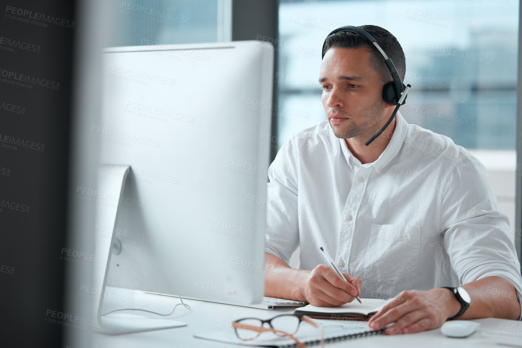 Buy stock photo Shot of a young male call center worker