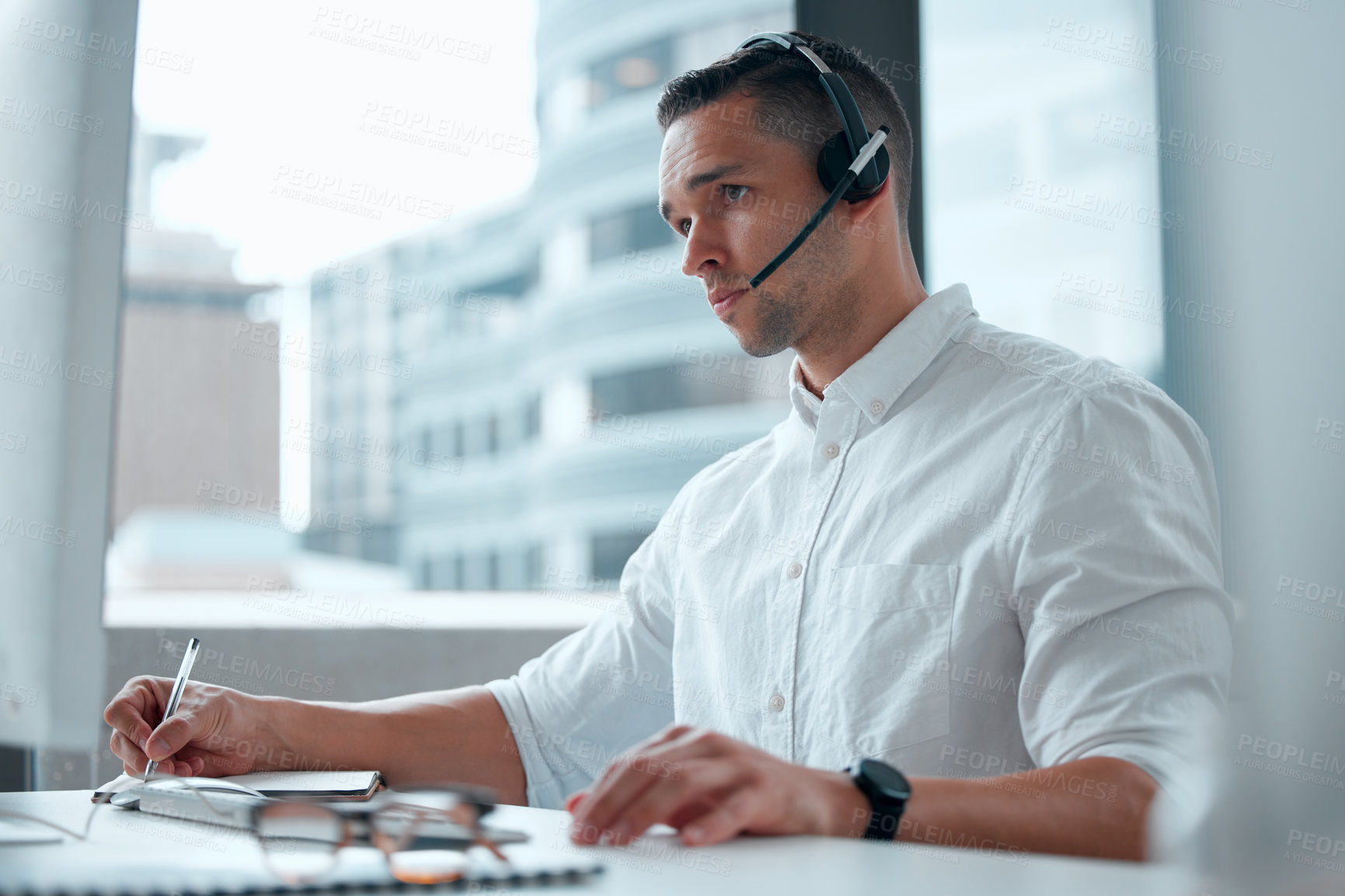 Buy stock photo Shot of a young male call center worker