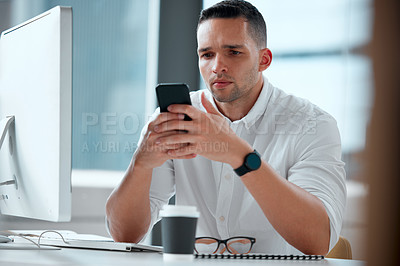 Buy stock photo Shot of a young male businessman using his smartphone to send a text