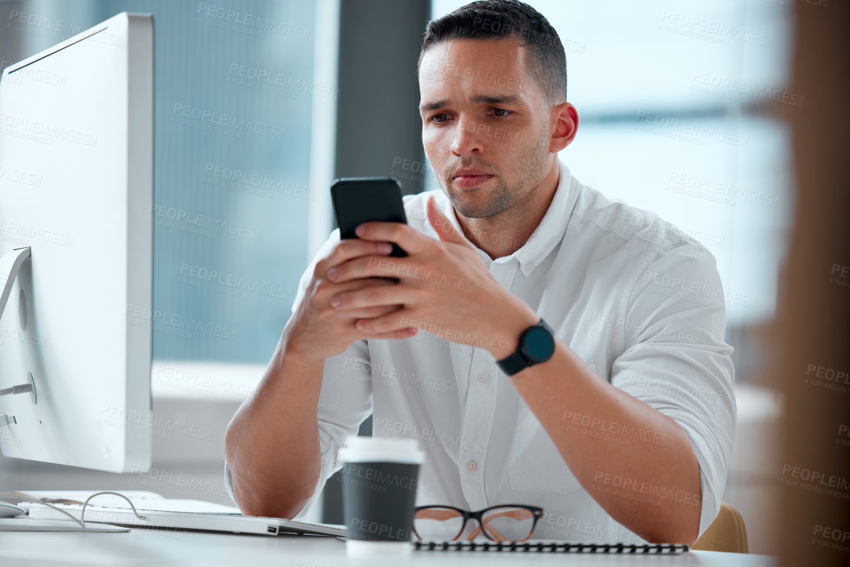 Buy stock photo Shot of a young male businessman using his smartphone to send a text
