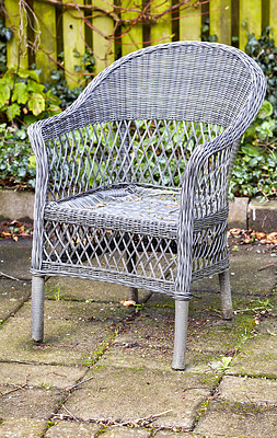 Buy stock photo Rattan armchair in a garden patio or terrace on a sunny day in autumn. Rustic outdoor furniture in a calm and peaceful environment surrounded by nature. Cosy spot to enjoy a break with fresh air