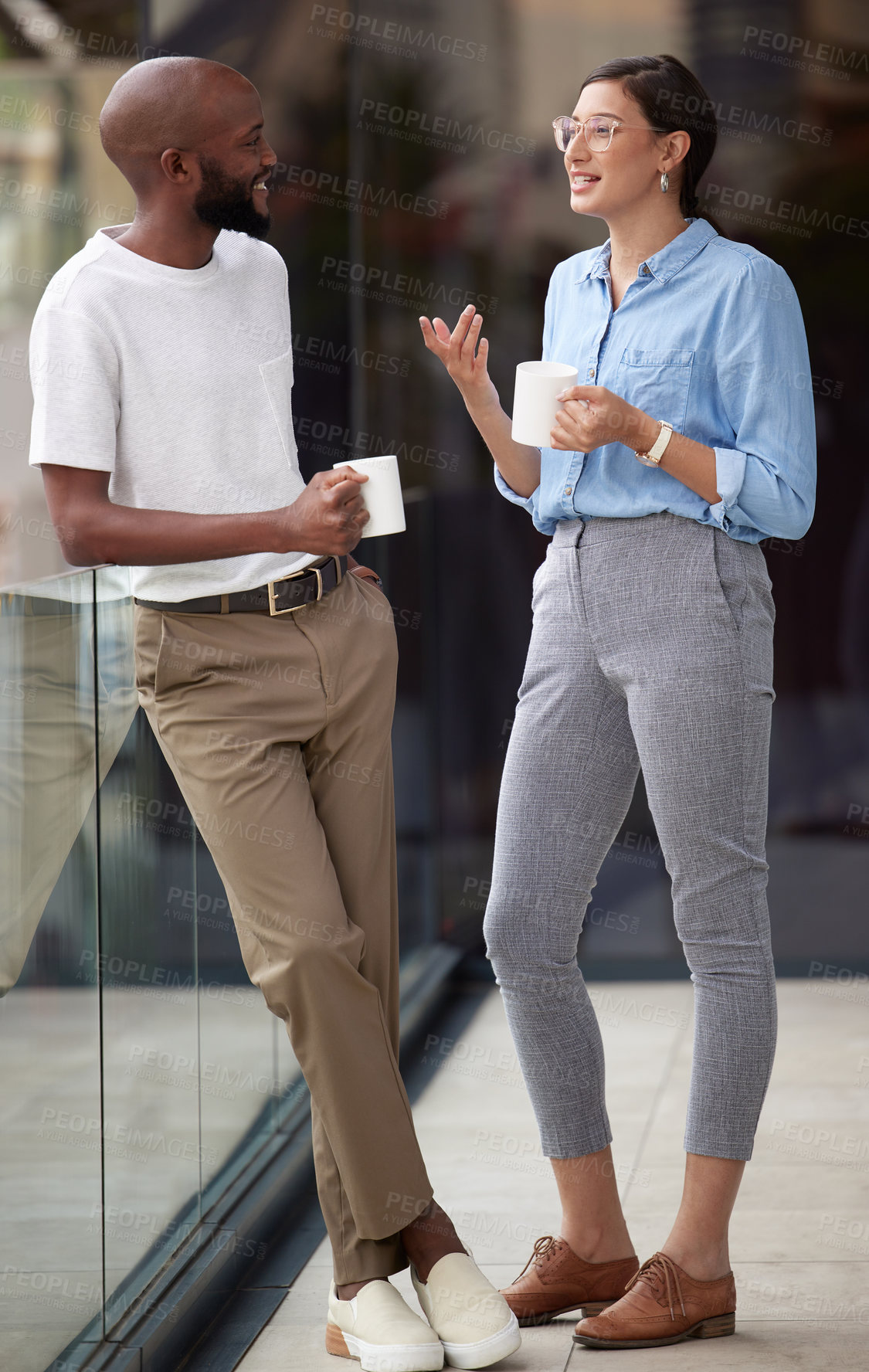 Buy stock photo Shot of two colleagues enjoying their coffee together