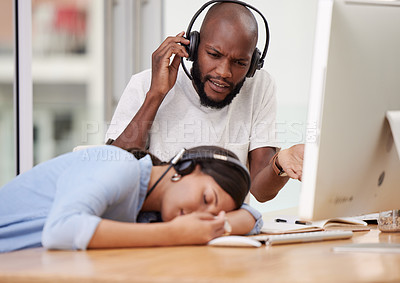 Buy stock photo Shot of a male colleague looking on as his coworker sleeps