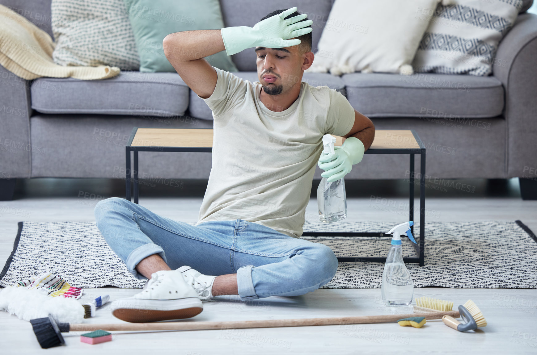 Buy stock photo Shot of a young man taking a break from chores at home