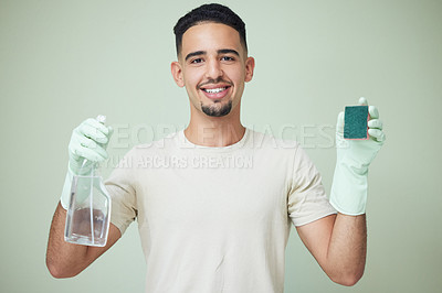 Buy stock photo Shot of a young man holding cleaning products against a green background