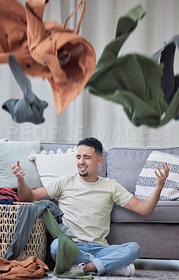 Buy stock photo Shot of a young man doing laundry at home