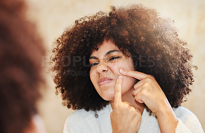 Buy stock photo Shot of a young woman squeezing a pimple while looking in the bathroom mirror