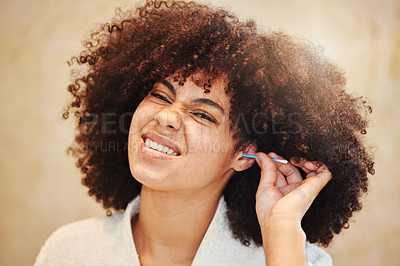 Buy stock photo Shot of a young woman cleaning her ear with a earbud