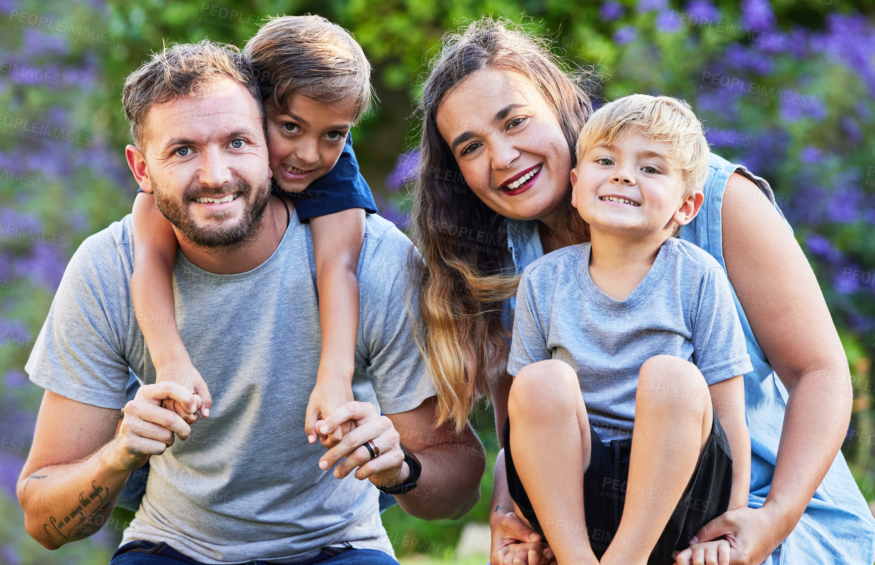 Buy stock photo Portrait of a beautiful family with their sons on their shoulders in a park