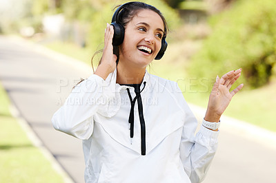 Buy stock photo Woman, headphones and runner with smile for fitness in outdoors with entertainment, wellness and health. Exercise, podcast and laugh with streaming on weekend with audio for relax with music in park