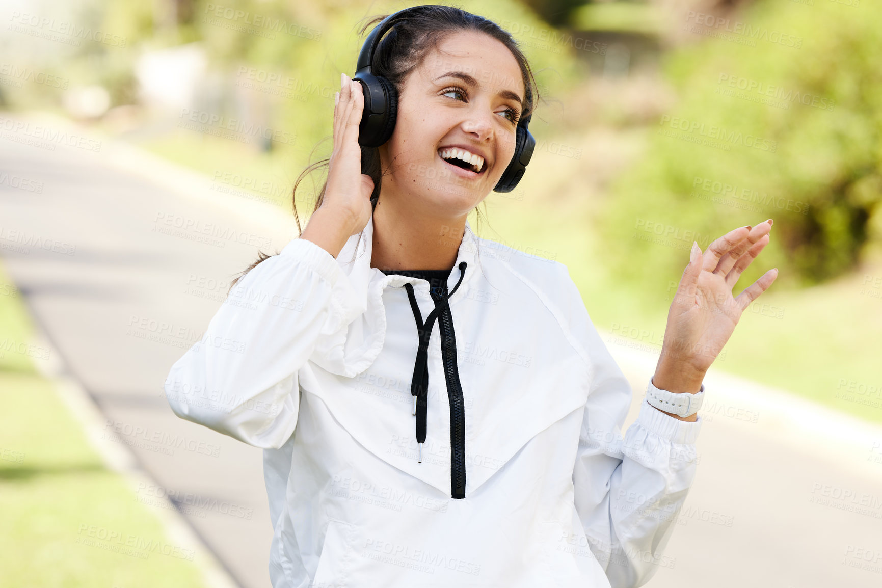 Buy stock photo Woman, headphones and runner with smile for fitness in outdoors with entertainment, wellness and health. Exercise, podcast and laugh with streaming on weekend with audio for relax with music in park