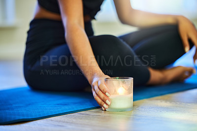 Buy stock photo Shot of a woman placing a candle on the floor before meditating