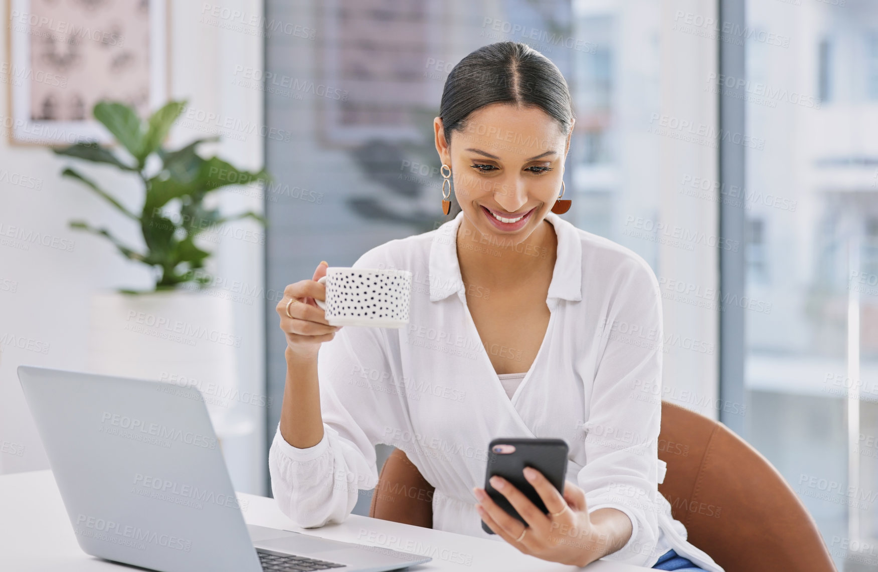 Buy stock photo Shot of a businesswoman using her cellphone while enjoying a coffee break in a modern office
