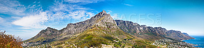 Buy stock photo Panorama of Table Mountain and hills next to the ocean against a cloudy blue sky background with copy space. Scenic view of mother nature, sea and flora. The calm and beauty of mother nature