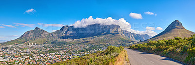 Buy stock photo Table Mountain is a hiking destination for tourists and locals surrounded by nature, trees and houses. Scenic road view of clouds resting on the popular tourist attraction in the city Cape Town.