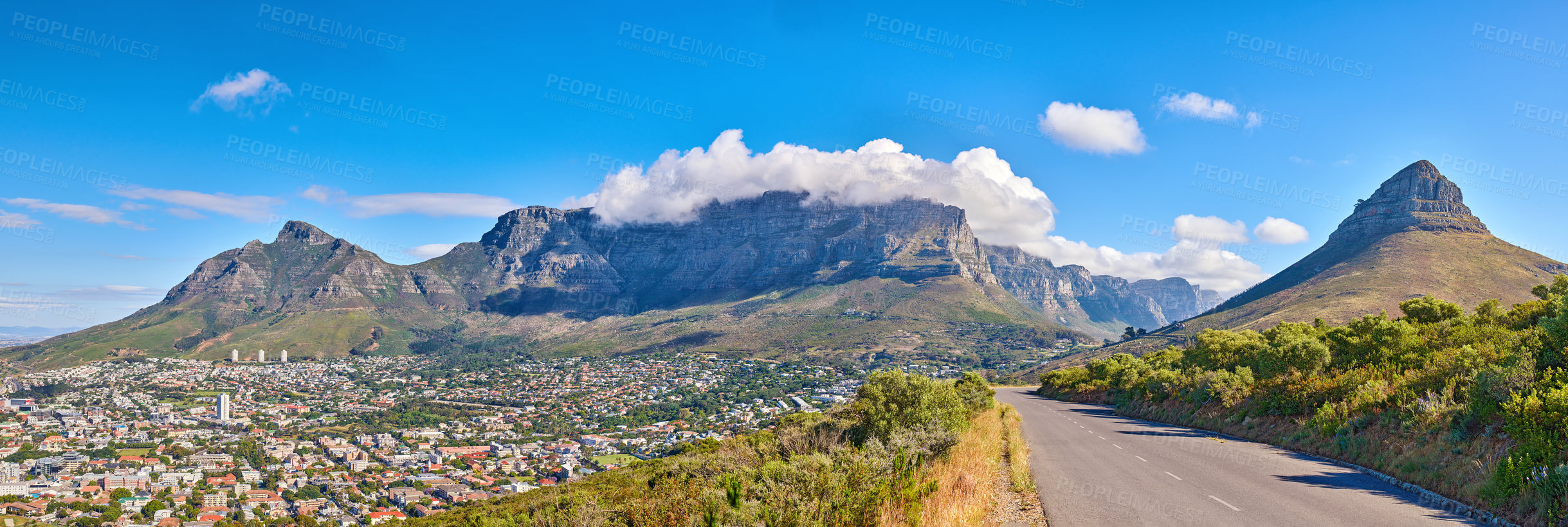 Buy stock photo Table Mountain is a hiking destination for tourists and locals surrounded by nature, trees and houses. Scenic road view of clouds resting on the popular tourist attraction in the city Cape Town.