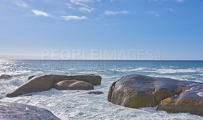 Buy stock photo Big rocks in the ocean or sea water with a blue sky background. Beautiful landscape with a scenic view of the beach with boulders on a summer day. Relaxing scenery of the seaside or nature