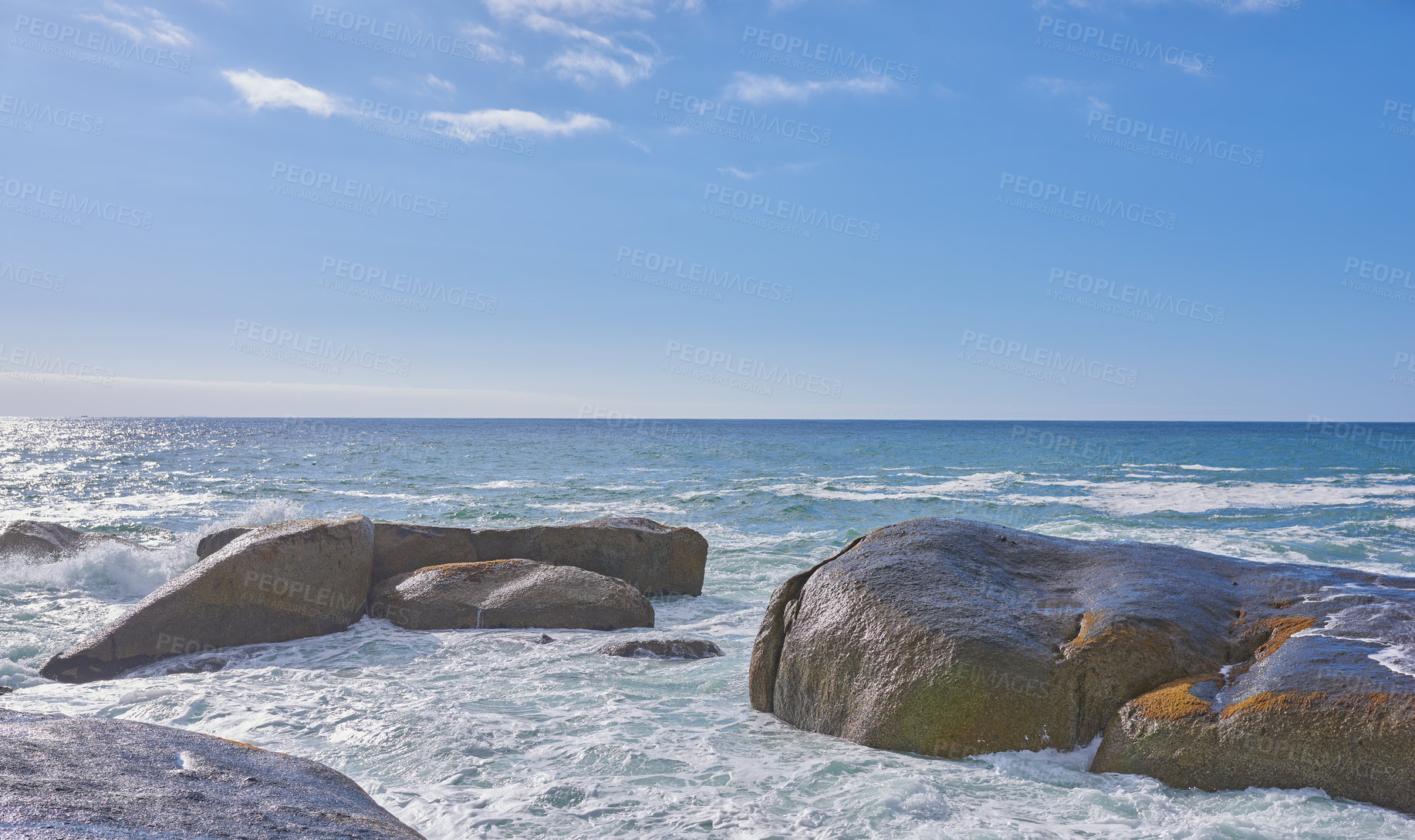 Buy stock photo Big rocks in the ocean or sea water with a blue sky background. Beautiful landscape with a scenic view of the beach with boulders on a summer day. Relaxing scenery of the seaside or nature