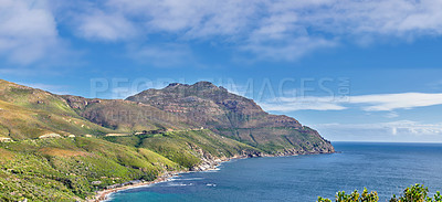 Buy stock photo A landscape of a mountainside with an ocean view and blue sky background with a lush, green botanical garden or national park. A scenic environment with rocky and rough terrain in a remote location