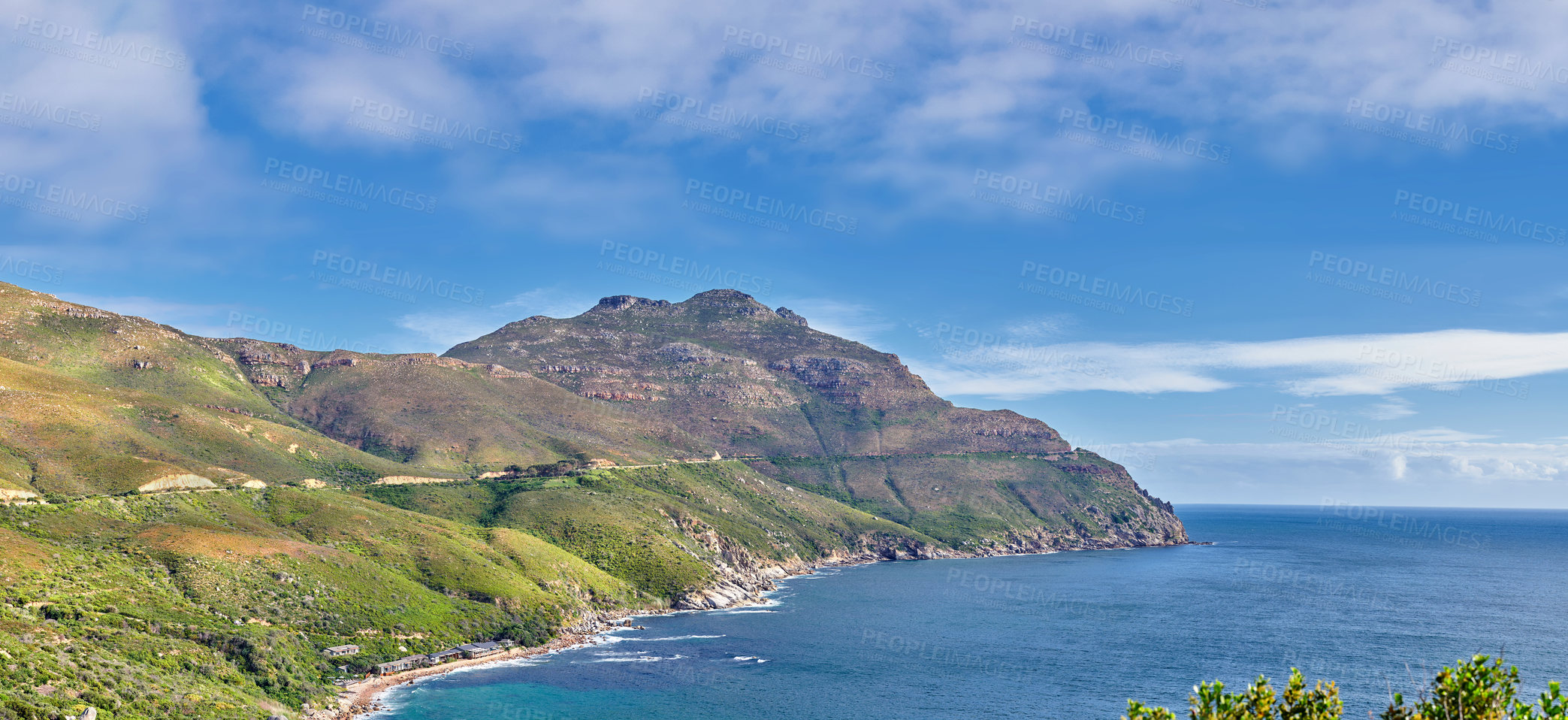 Buy stock photo A landscape of a mountainside with an ocean view and blue sky background with a lush, green botanical garden or national park. A scenic environment with rocky and rough terrain in a remote location