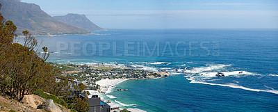 Buy stock photo Panorama of a mountain coastline with quiet ocean against a blue sky in South Africa from above. Scenic wallpaper of a serene landscape of calm waves near Camps Bay with a peaceful sea view.