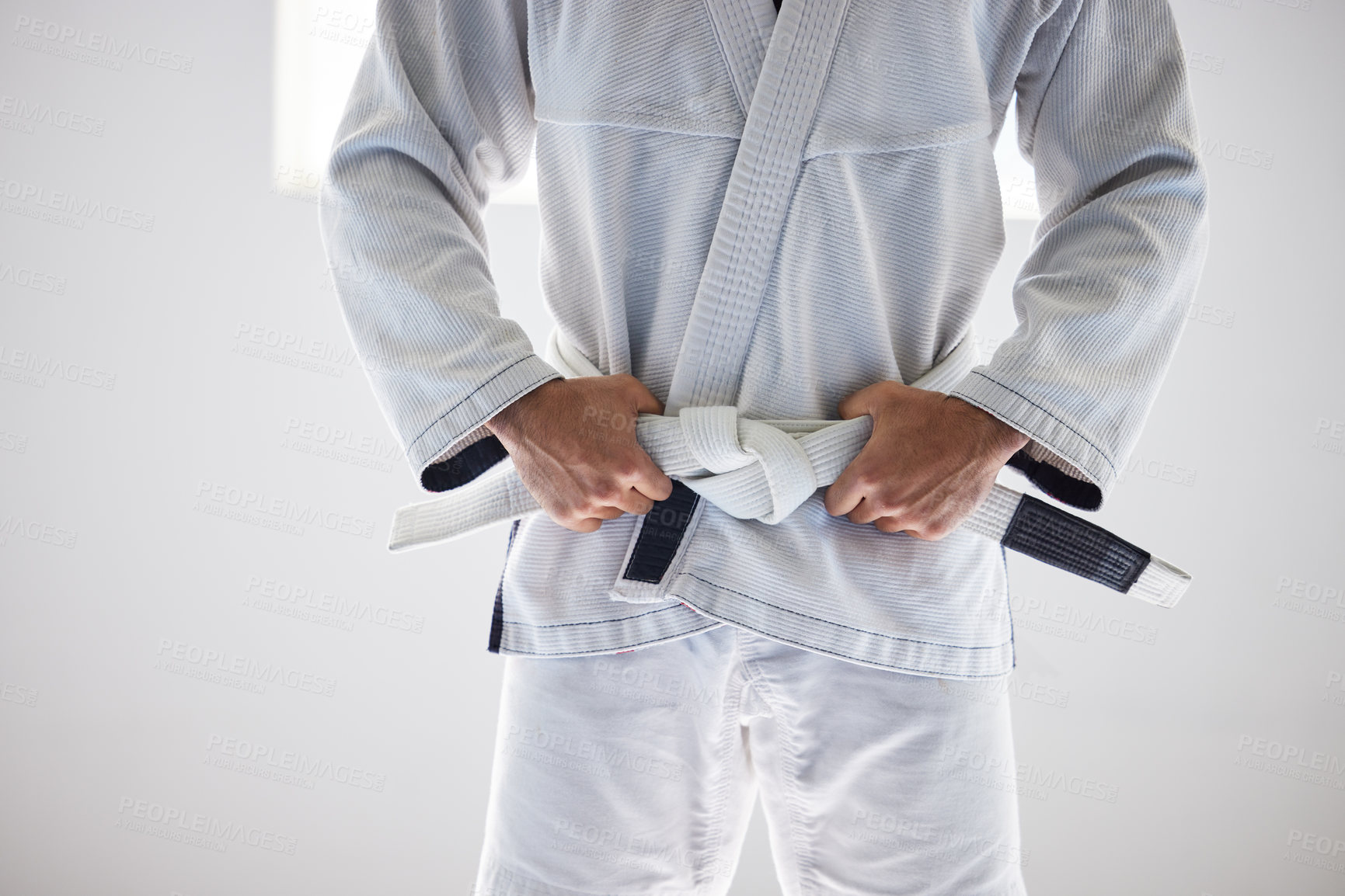 Buy stock photo Man, closeup or belt for martial arts sport in fitness center for self defense, fighting or discipline. Pro athlete, jiu-jitsu and hands on uniform for training, practice or wellness for competition 