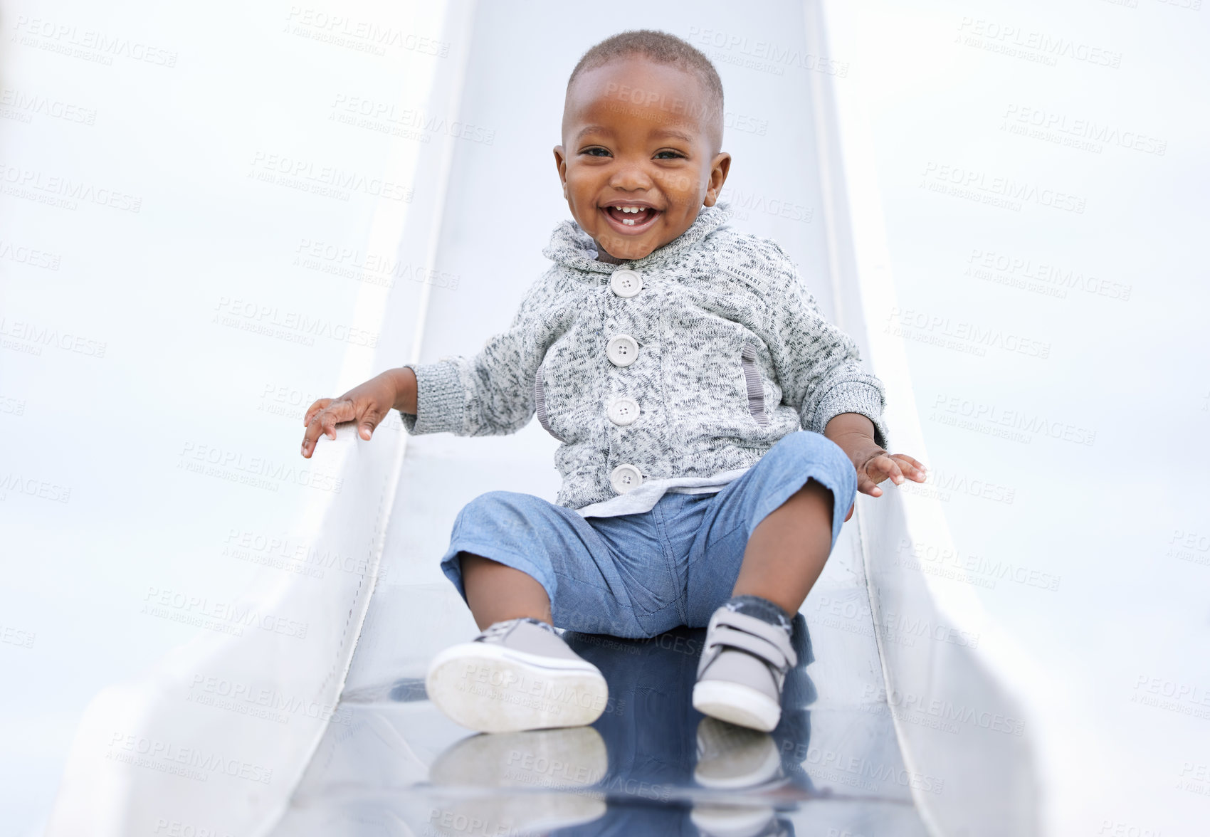 Buy stock photo Shot of a baby boy playing on the slide  in the park