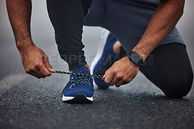 Buy stock photo Man, hands and tying shoes on road for running, fitness or cardio workout on asphalt in the outdoors. Hand of male person, runner or athlete tie shoe and getting ready for sports training on street