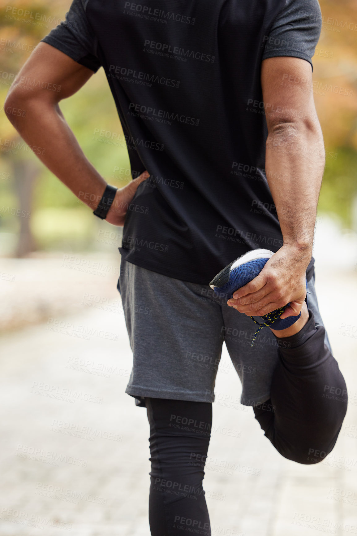 Buy stock photo Rearview shot of an unrecognisable man stretching his legs while exercising outdoors