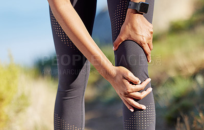 Buy stock photo Closeup shot of an unrecognisable woman holding her knee in pain while exercising outdoors