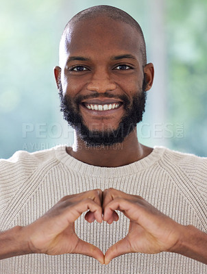 Buy stock photo Shot of a young man making a heart shape with his hands
