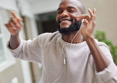 Buy stock photo Shot of a young man dancing while listening to music at home