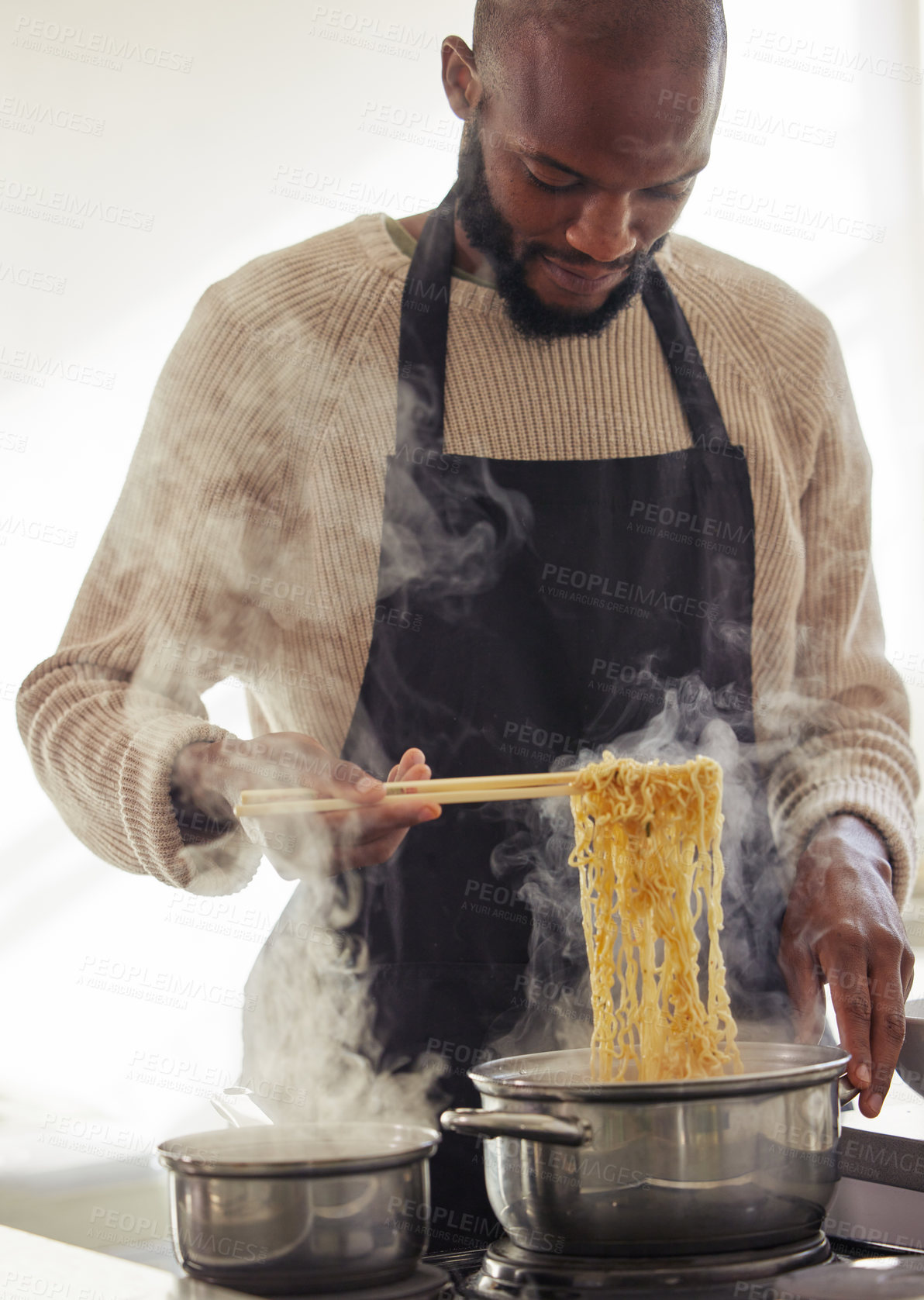 Buy stock photo Man, cooking noodles and pot with steam at home for lunch or dinner, busy and hungry for food with preparation. Catering, African chef with chopsticks for Asian cuisine and nutrition in kitchen