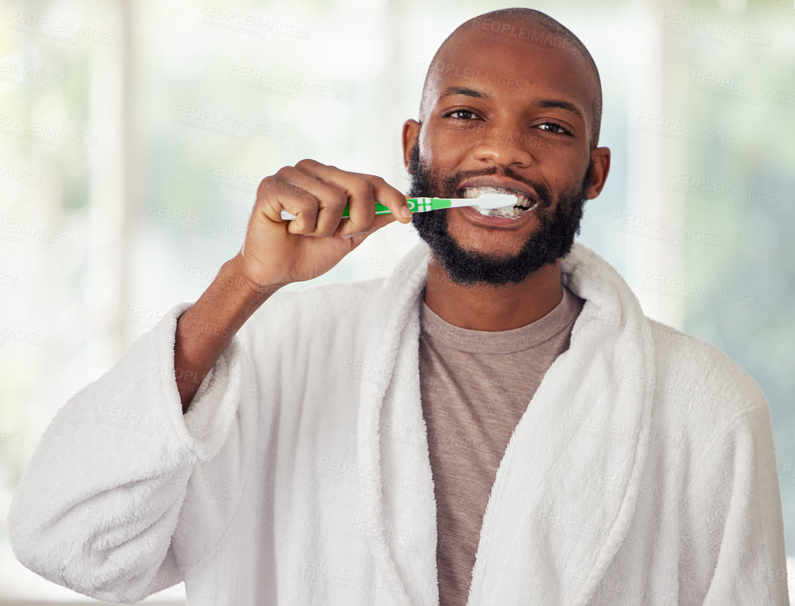 Buy stock photo Shot of a young man brushing his teeth at home