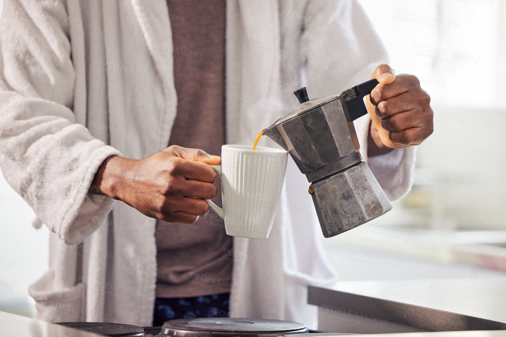 Buy stock photo Shot of an unrecognizable man pouring coffee into a cup at home