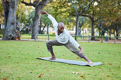Buy stock photo Full length shot of a handsome young man practicing yoga outside in the park