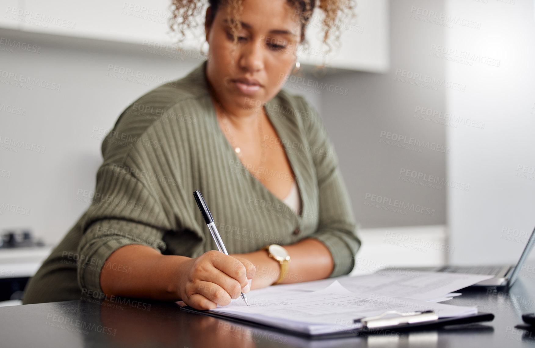 Buy stock photo Shot of a woman filling in some paperwork at home