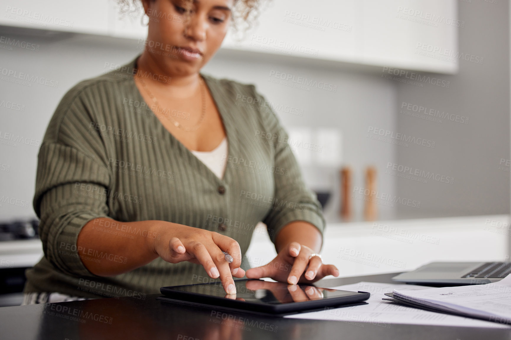 Buy stock photo Shot of a woman using a digital tablet and going through paperwork at home