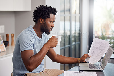Buy stock photo Shot of a man going through some paperwork and looking worried at home while having coffee