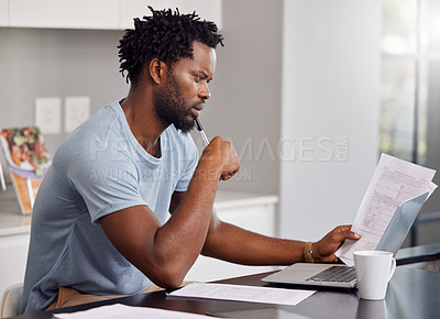 Buy stock photo Shot of a man going through some paperwork and looking worried at home