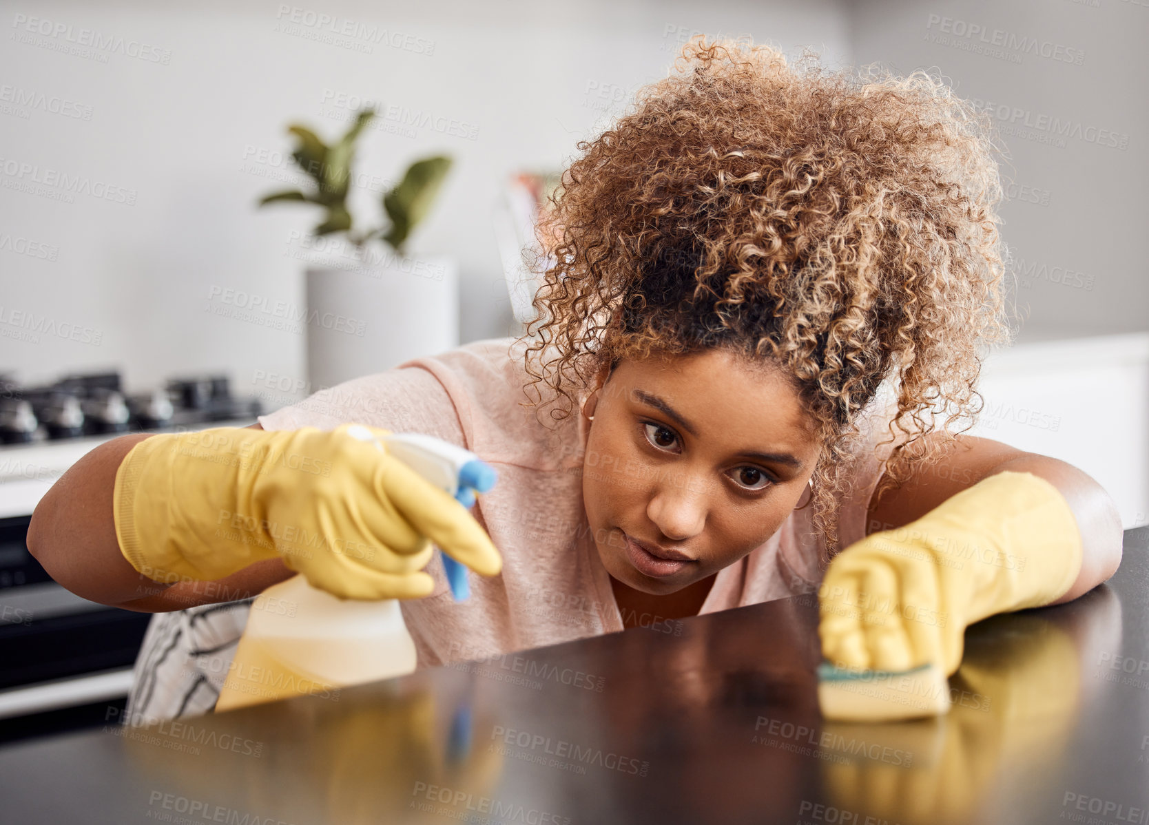 Buy stock photo Shot of a young woman cleaning a countertop at home