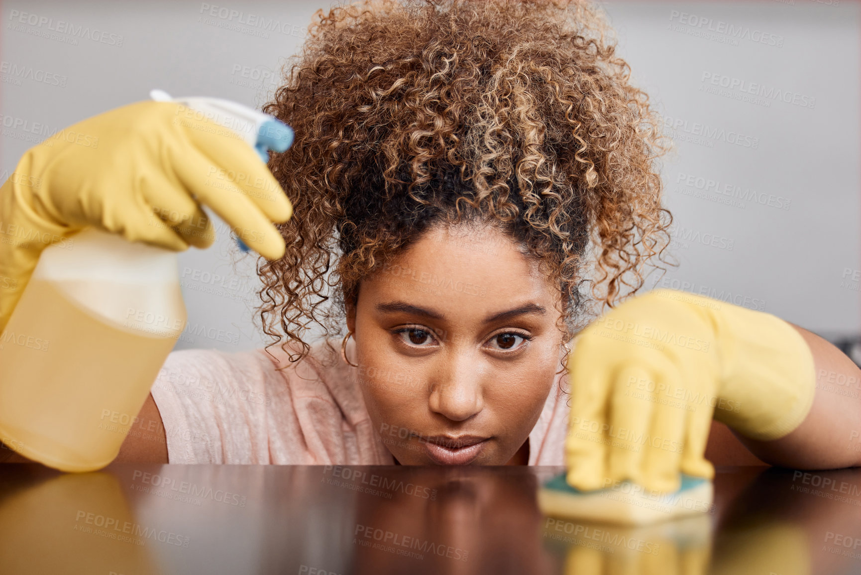 Buy stock photo Shot of a young woman cleaning a countertop at home