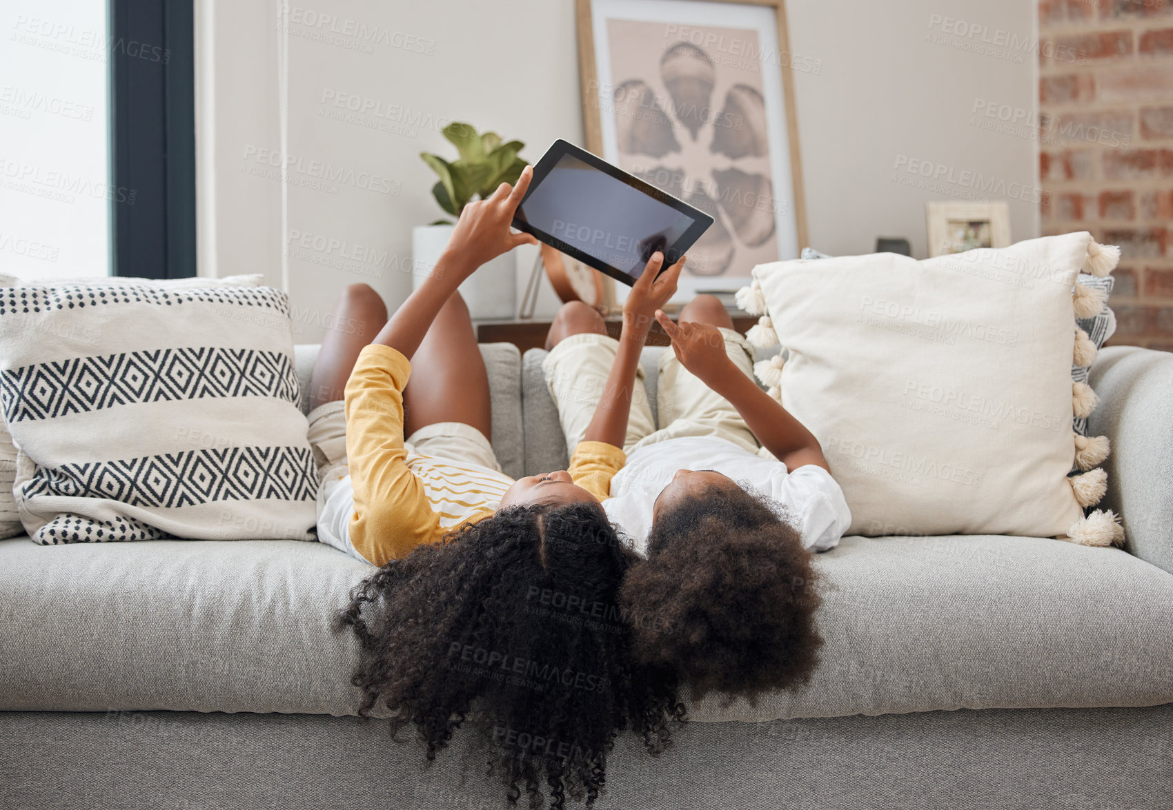 Buy stock photo Relax, sisters and girl with a tablet, home and connection for social media, communication and chatting. Female children on a couch, young people and kids with technology, typing and watching videos