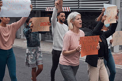 Buy stock photo Cropped shot of a group of demonstrators holding up signs protesting against the covid 19 vaccine