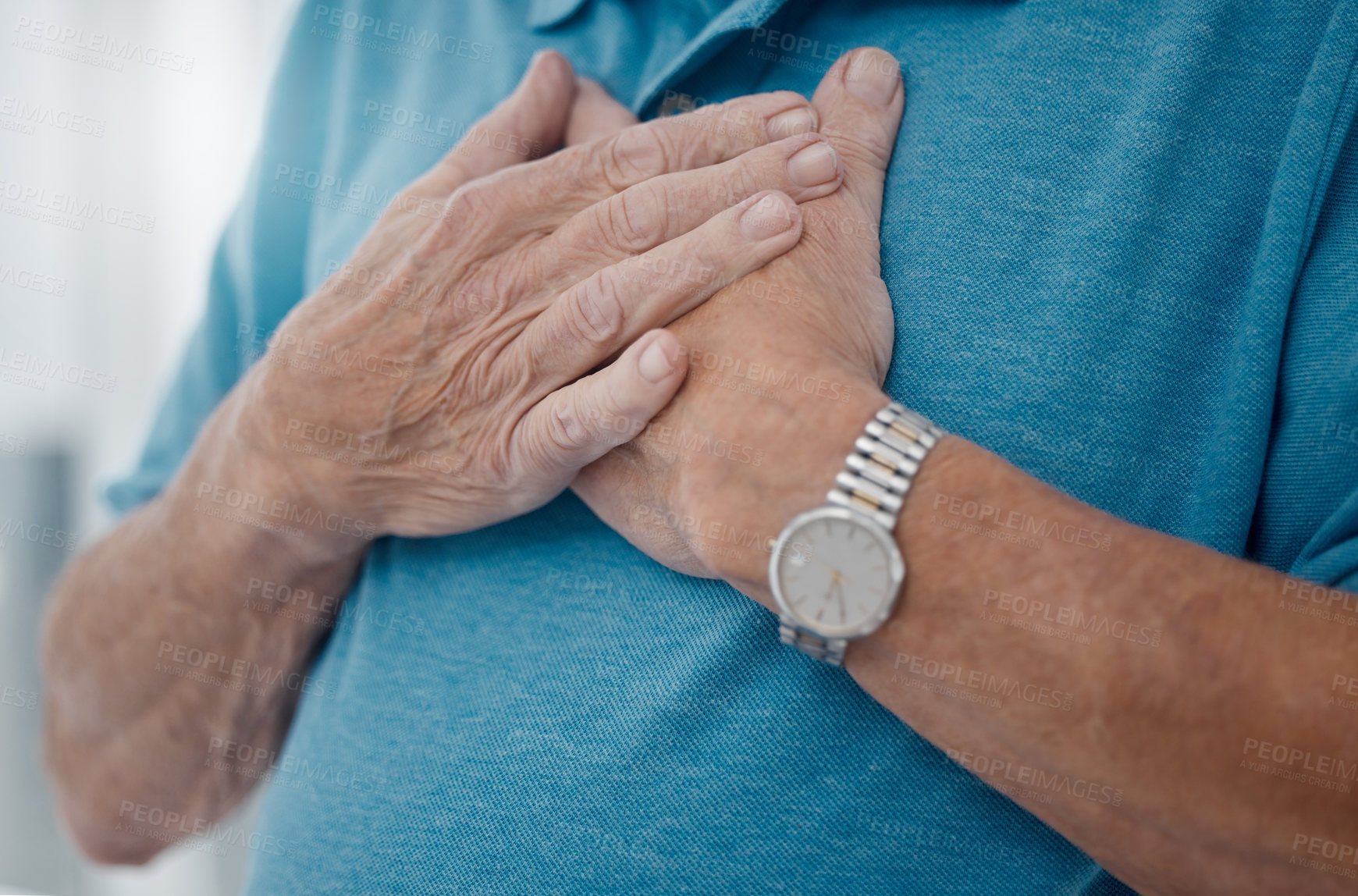 Buy stock photo Shot of an unrecognizable man holding his hands to his heart in a hospital