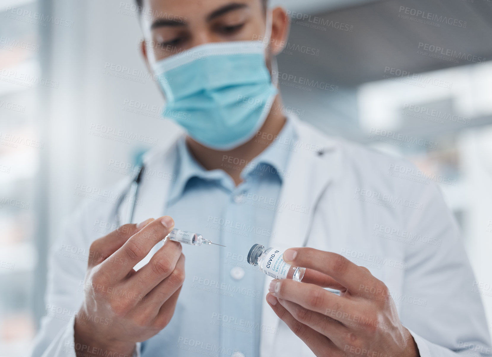 Buy stock photo Cropped shot of a young male doctor preparing the covid 19 vaccination for a patient