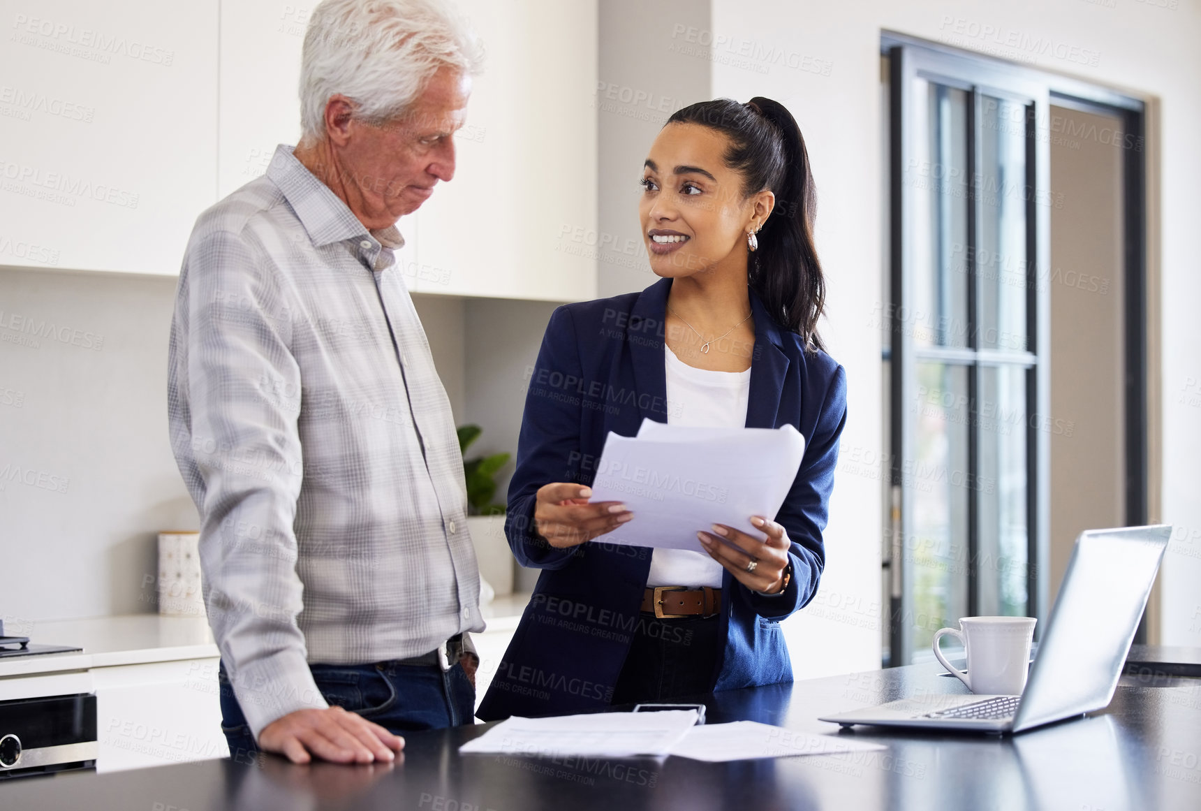 Buy stock photo Cropped shot of an attractive young female broker going over some paperwork with a senior male client