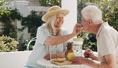 Buy stock photo Senior, couple or pineapple in garden with joy for retirement, fruit and feeding for nutrition. Husband, wife or old on patio with happiness and water, breakfast in summer with partner in home
