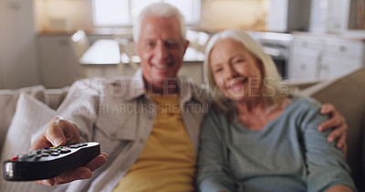 Buy stock photo Shot of a senior couple sitting on the sofa together at home and watching tv
