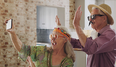 Buy stock photo Senior couple, video call and wave in home, silly and costume for joke on phone in retirement. Elderly people, greeting and connect on app for conversation, talking and goofy accessories for fun